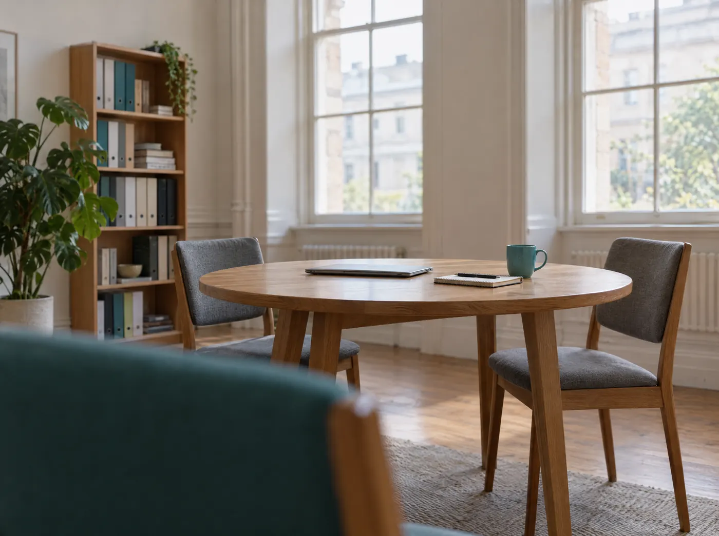 Heller Beratungsraum im Altbau mit rundem Tisch und zwei Stühlen, Symbolbild für Consulting Bridge